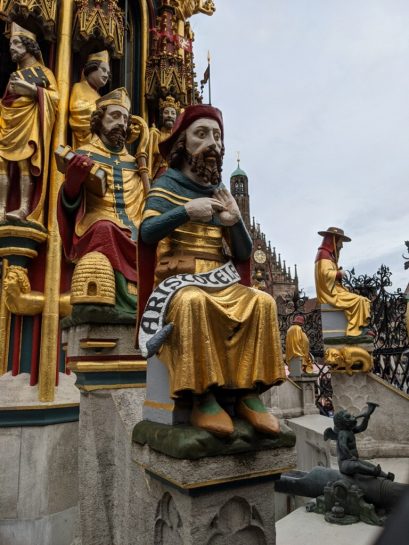 Colorful statue of Aristotle located at the beautiful 14th century Schöner Brunnen fountain in Nuremberg.
